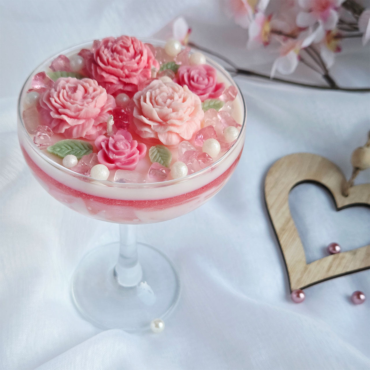 Handgefertigte florale Duftkerze mit modellierten Wachsrosen und Rosenquarz