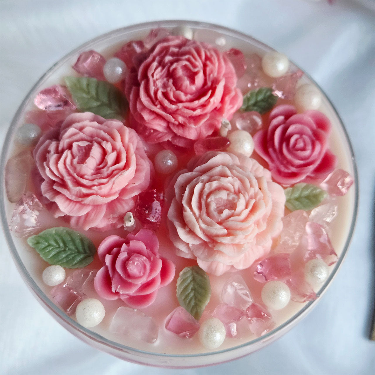 Detailaufnahme der modellierten Wachsrosen auf einer floralen Duftkerze