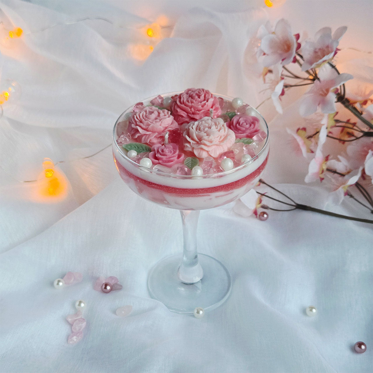 Detailansicht einer handgefertigten Blumenkerze im Glas mit floralen Wachselementen