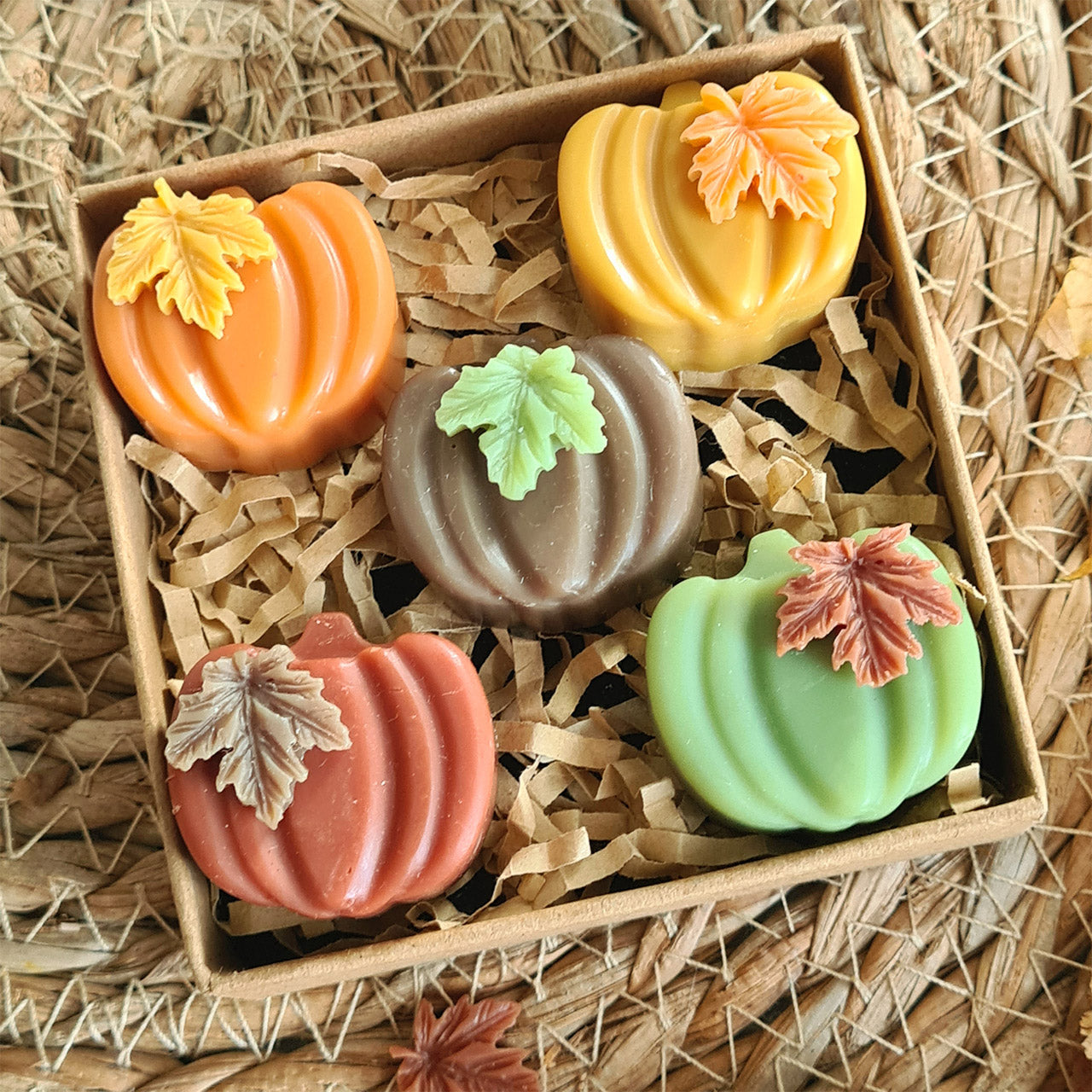 Brennende Kerze Kürbiszauber auf Holztisch mit Deko