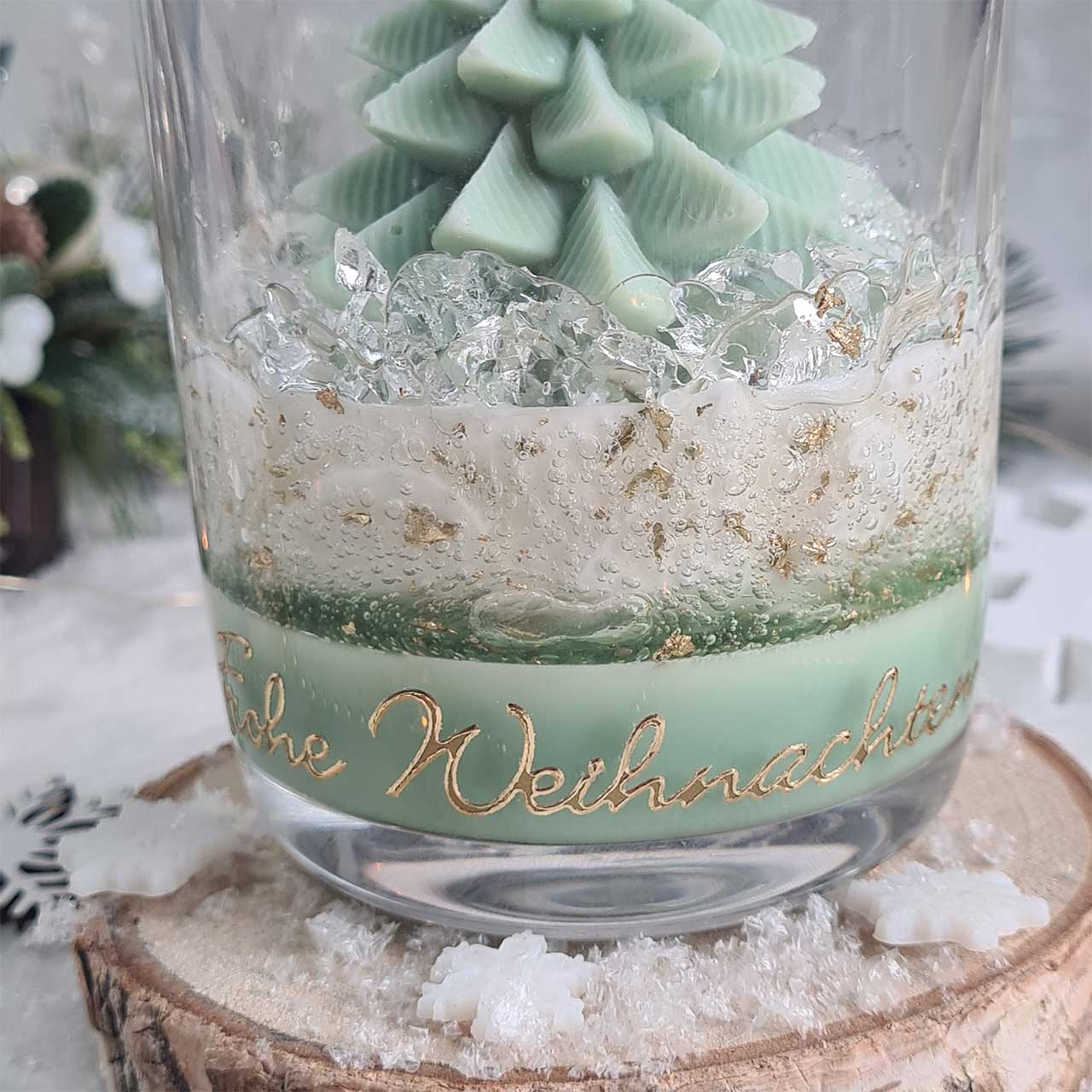 Winterdeko mit Weihnachtskerze im Glas und Schneeflocken